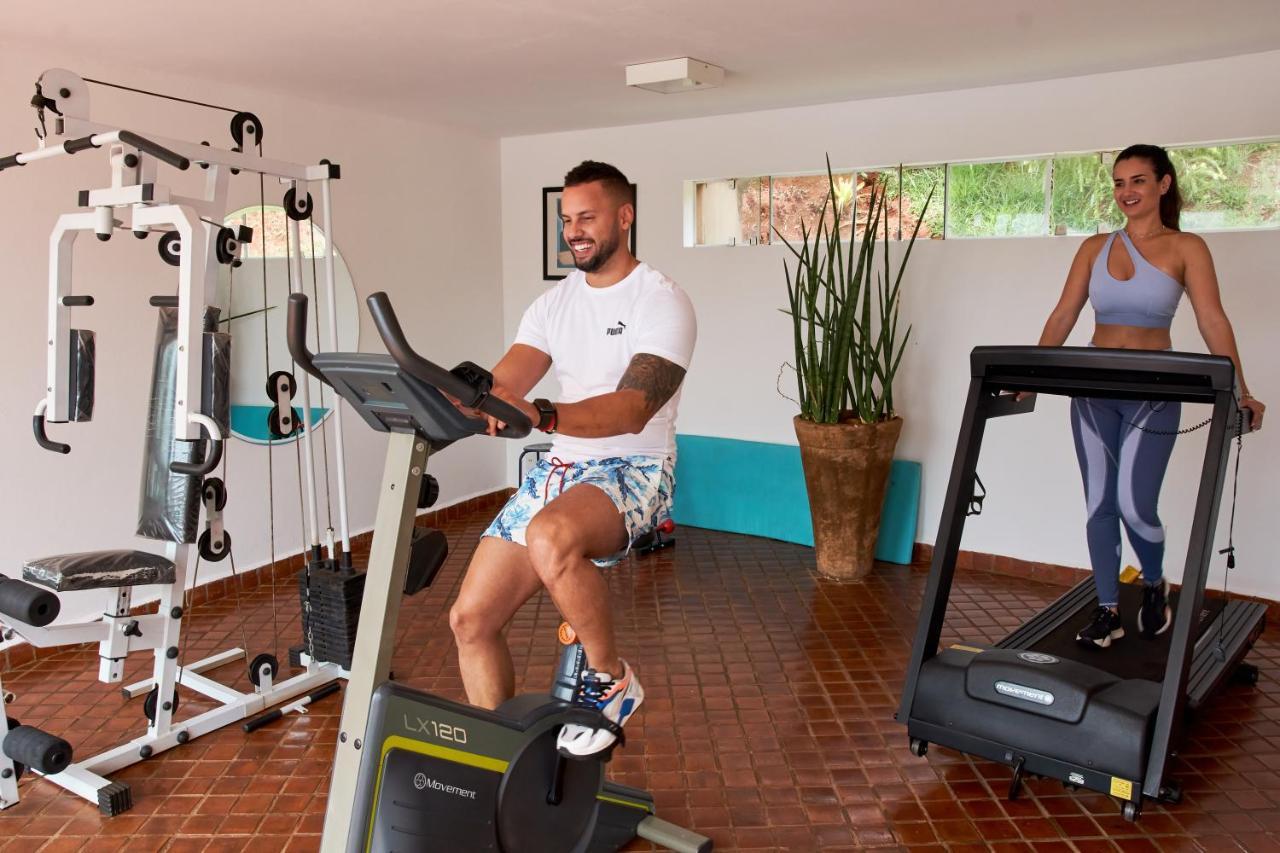 Hotel Boutique Frangipani Brotas Buitenkant foto A man and a woman exercise on a treadmill and a stationary bicycle.