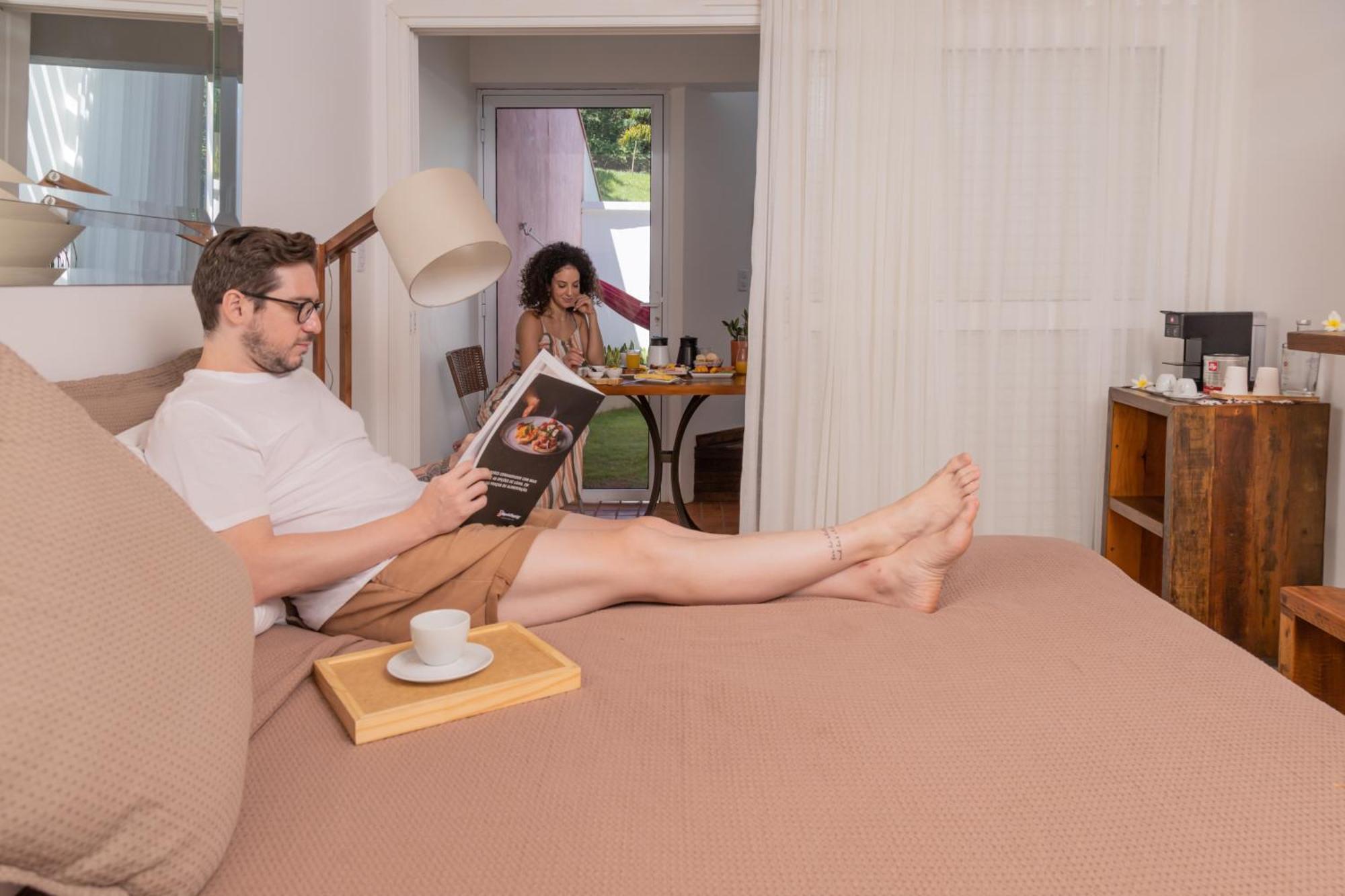 Hotel Boutique Frangipani Brotas Buitenkant foto A man reading a book while a woman cooks